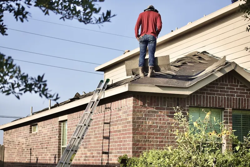 Professional roofer working on a residential roof in River Falls